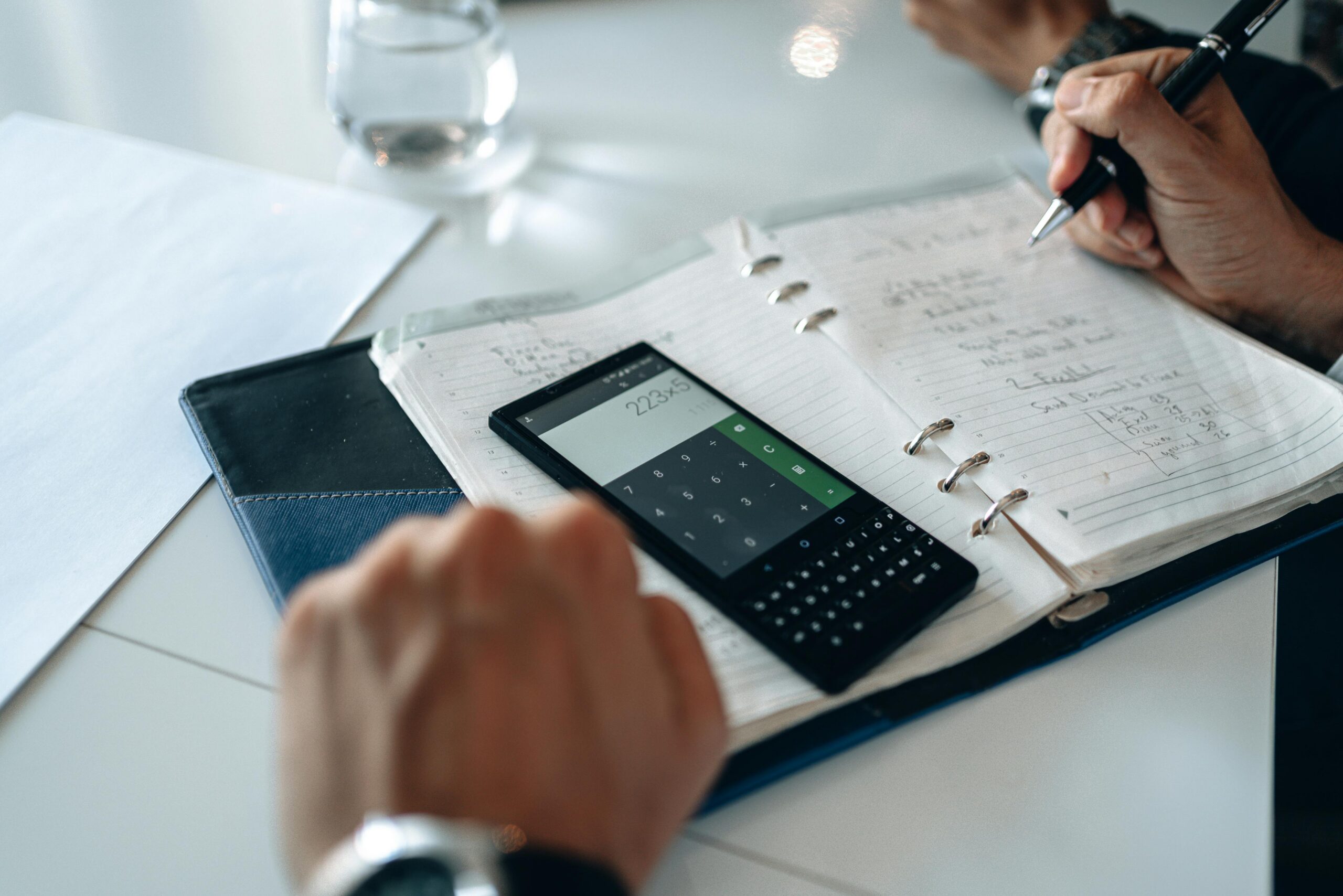 Calculator and notes on a neutral desk, representing payment information for psychology and counselling appointments.