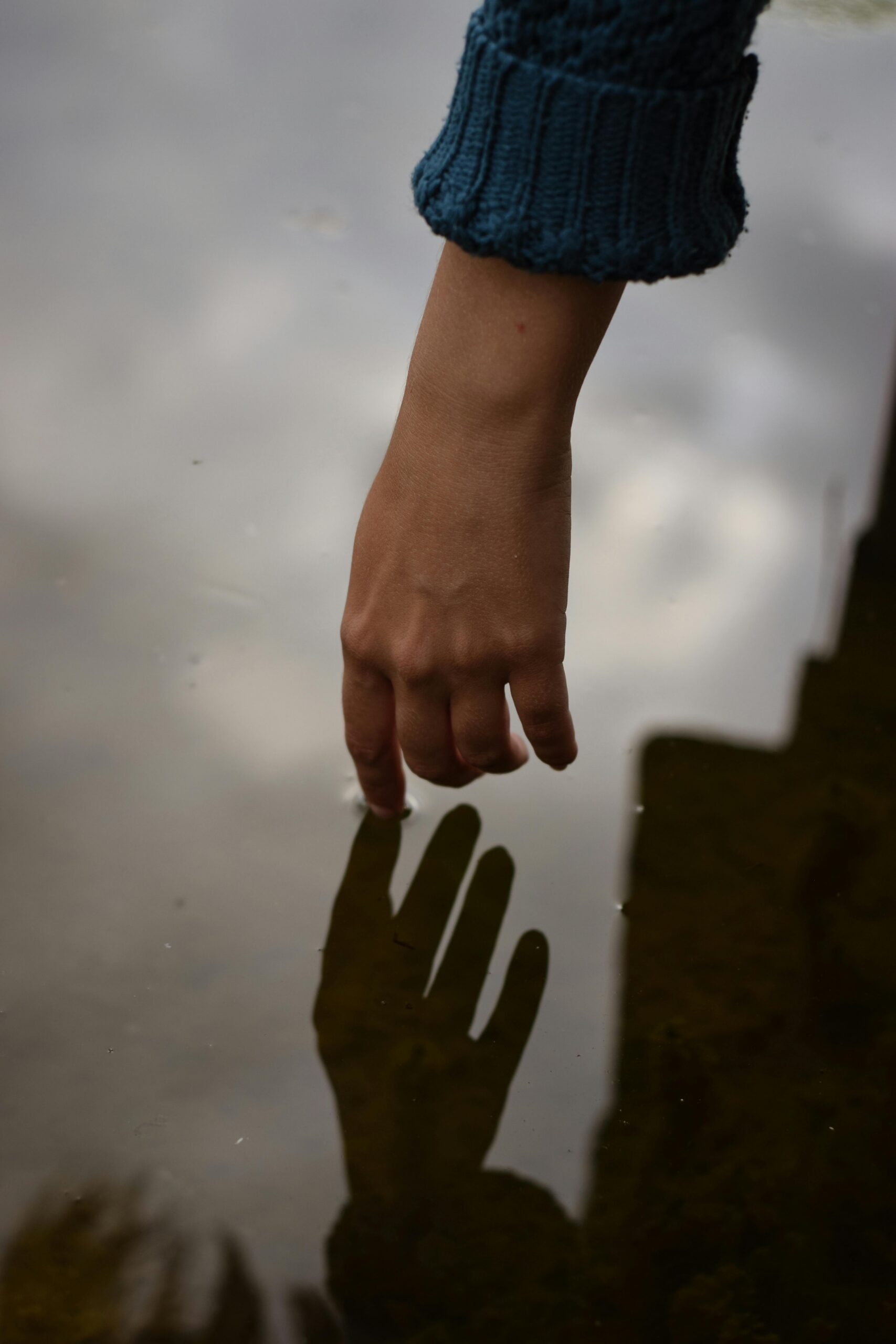 A hand reaching toward a shadow, representing the experience of anxiety symptoms and the need for support.