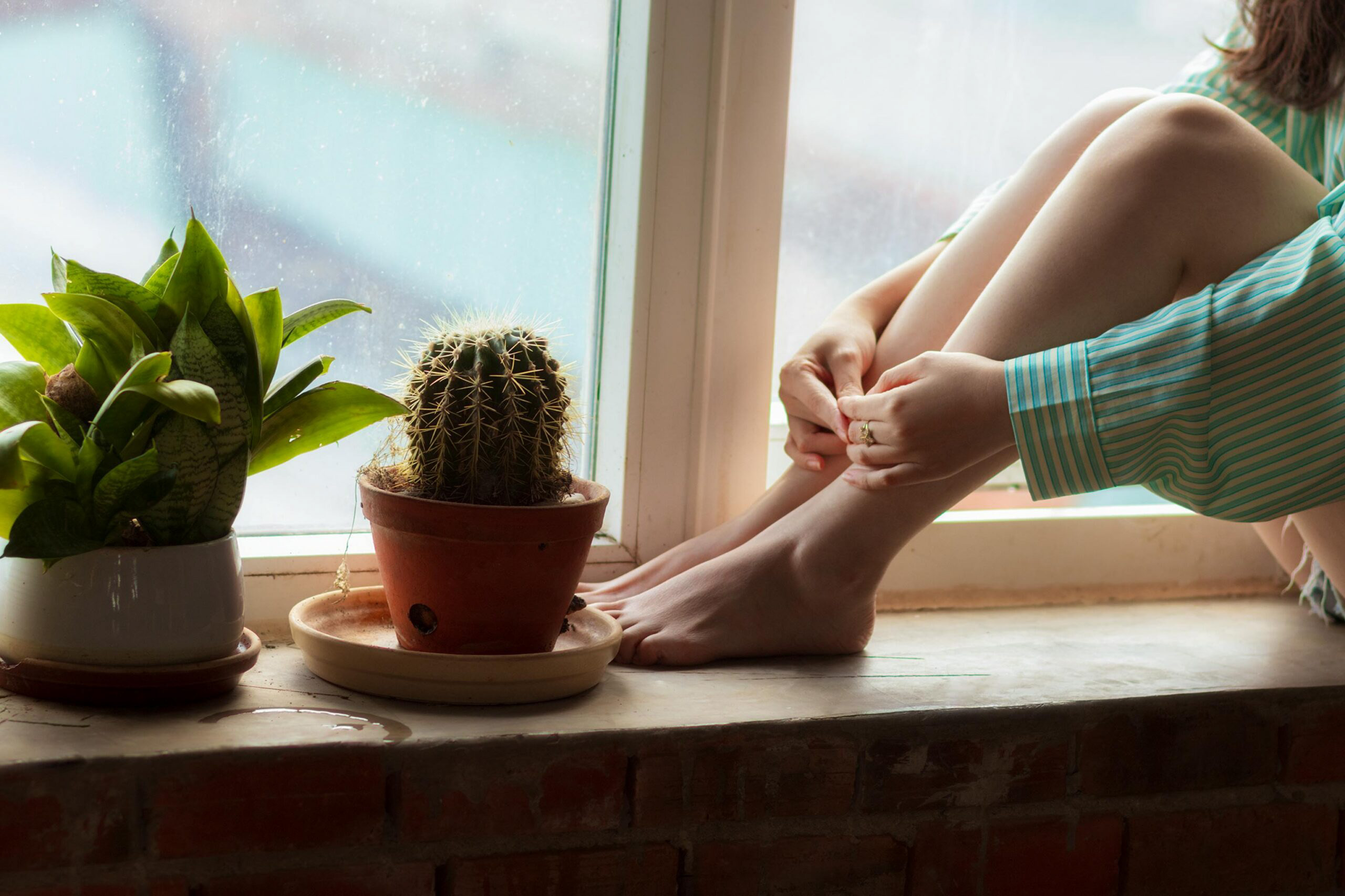 Person sitting quietly near a window, representing individual counselling and psychological support in Darwin