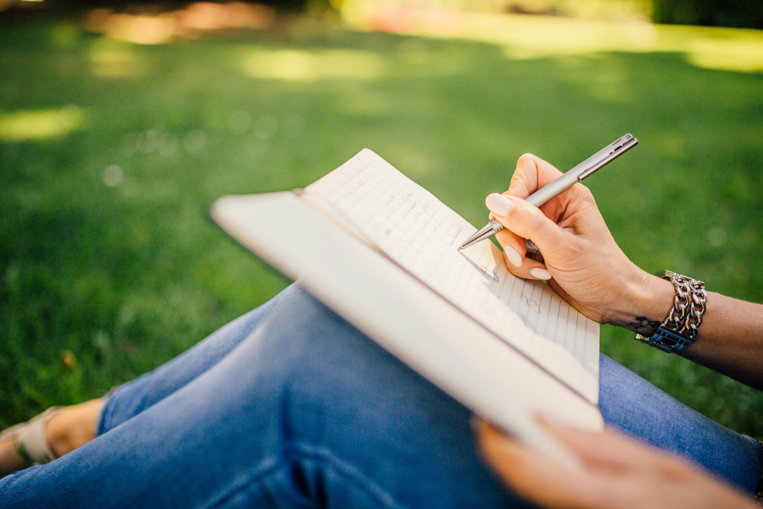 Person holding a pen and journaling, representing practical strategies for managing anxiety.